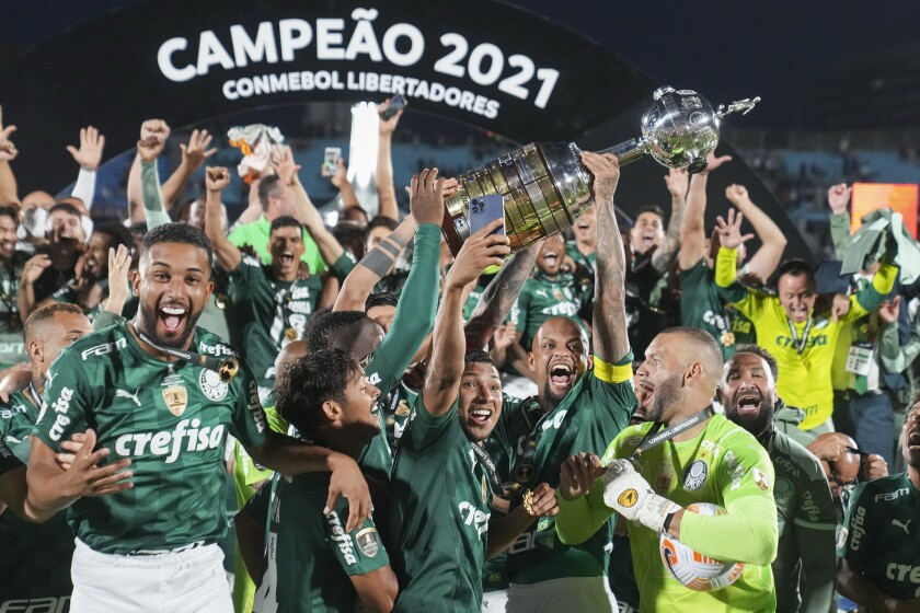 Players of Brazil's Palmeiras celebrate with the trophy after beating Brazil's Flamengo 2-1 in the Copa Libertadores final soccer match in Montevideo, Uruguay, Saturday, Nov. 27, 2021. (AP Photo/Matilde Campodonico)