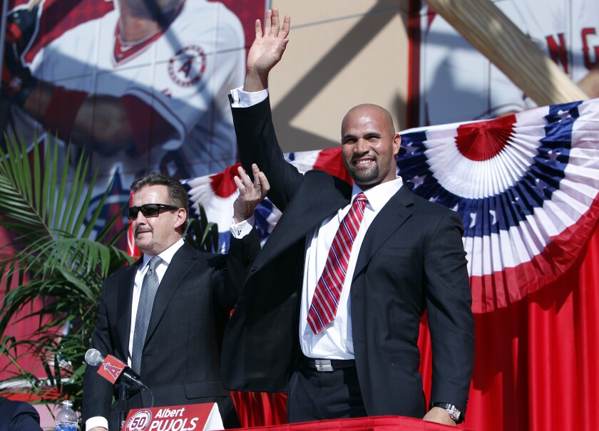 Arte Moreno hoists the arm of Albert Pujols at a news conference