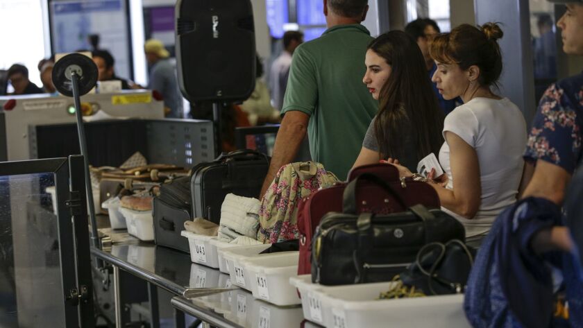 Travelers line up at a checkpoint at Los Angeles International Airport in May 2016. The American Civil Liberties Union has filed a lawsuit to demand documents related to the Transportation Security Administration's search of electronic devices on domestic flights.