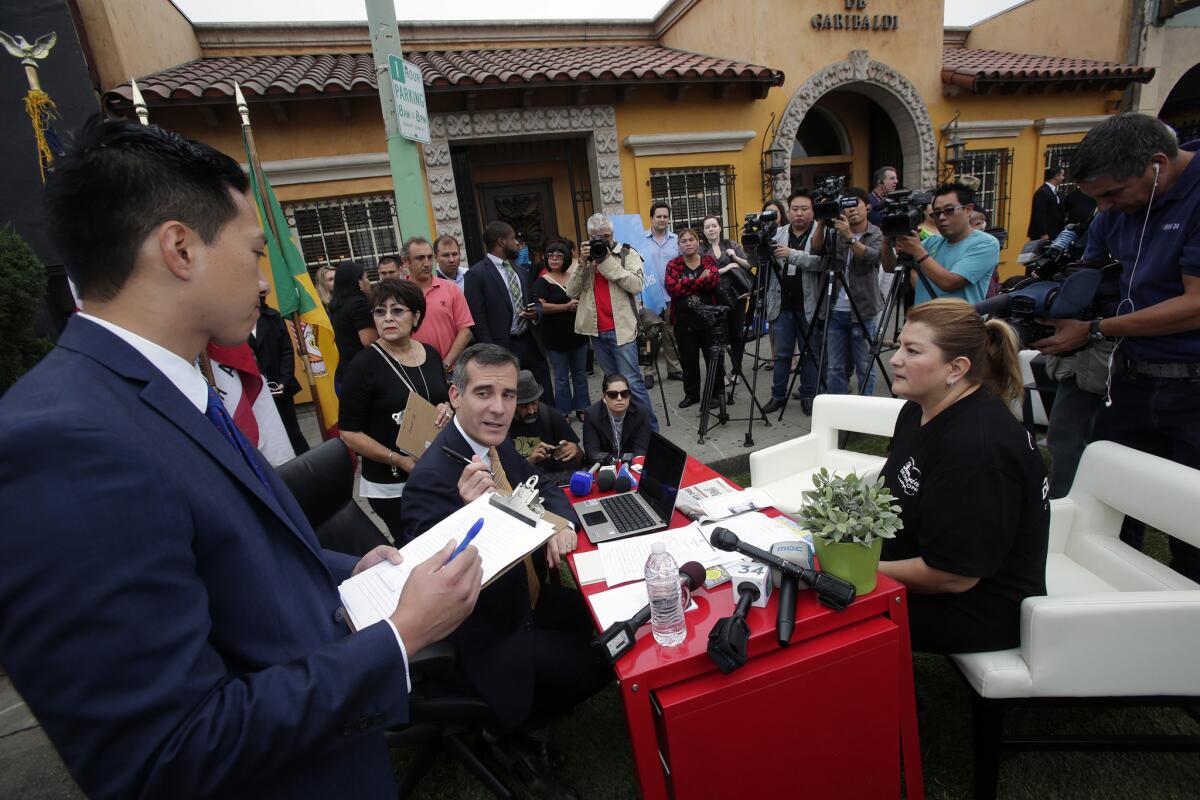 L.A. Mayor Eric Garcetti, center, directs a staff member during a meeting with restaurant owner Arcelia Gonzalez at the Mayor's Help Desk, which was temporarily set up curbside at 1842 E. 1st St. to answer constituents' questions and complaints.