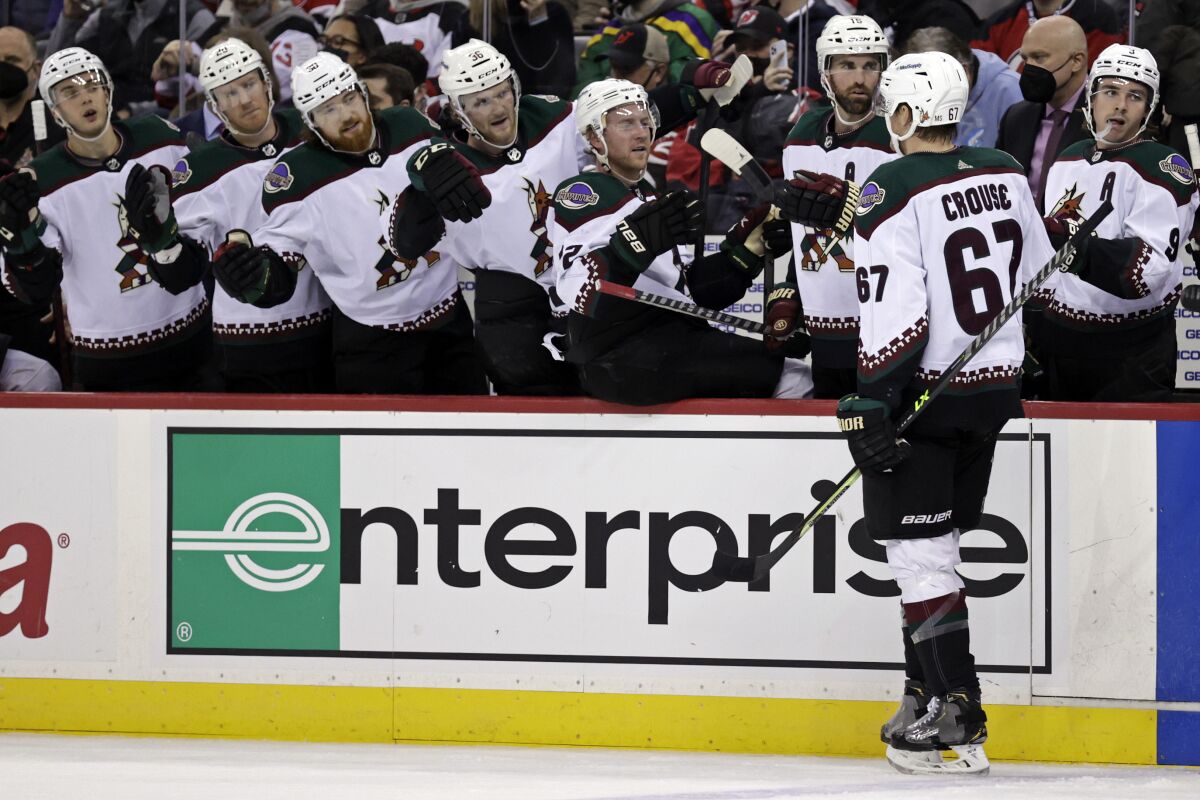 Arizona Coyotes left wing Lawson Crouse (67) celebrates with teammates after scoring a goal against the New Jersey Devils during the second period of an NHL hockey game Wednesday, Jan. 19, 2022, in Newark, N.J. (AP Photo/Adam Hunger)