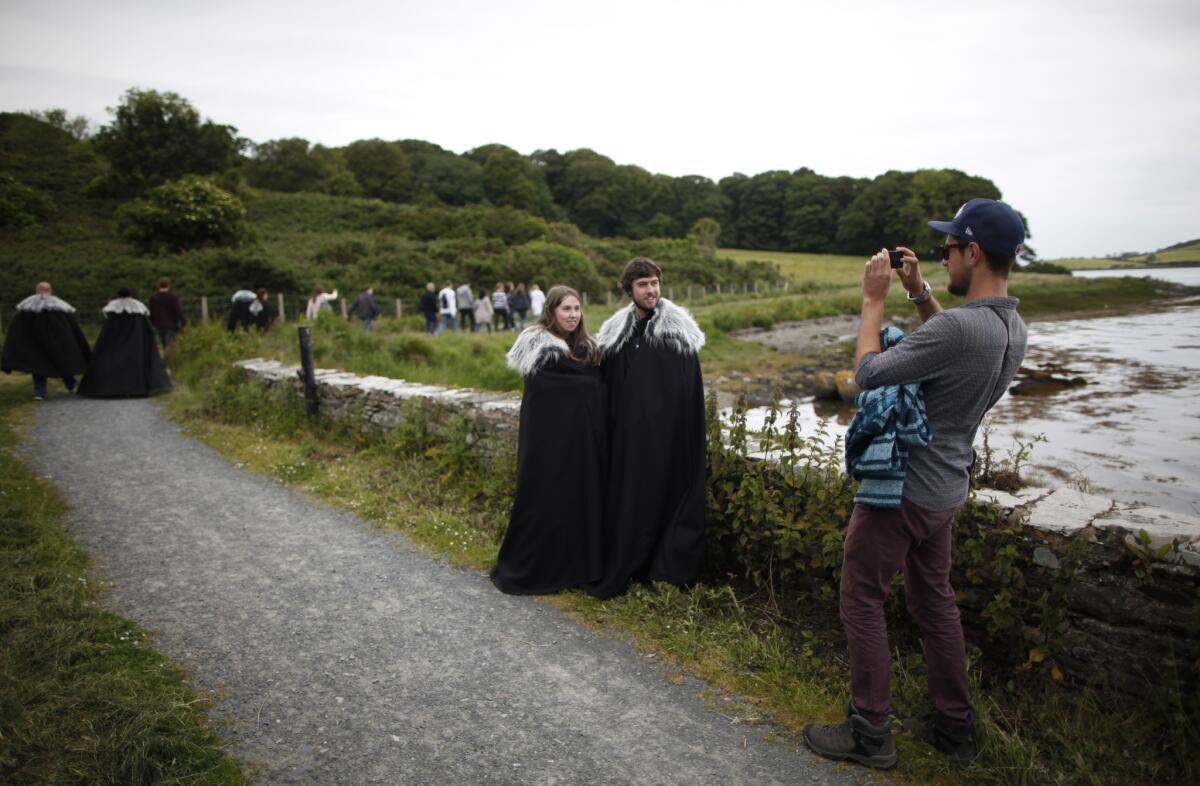 "Game of Thrones" fans stop for a picture on their way to Audleys field and castle in Strangford, Northern Ireland. Audleys field and castle was used for filming Season 1 as King Robert Baratheon and his retinue arrive at Winterfell. (Peter Morrison / AP)