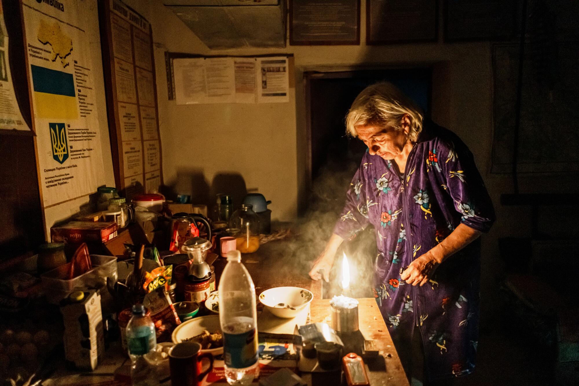 Nadia Schamal tries to put out and save her candles in a shelter near Velyka Novosilka, Ukraine