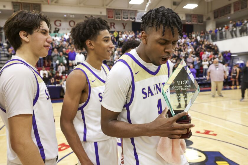 SAN DIEGO, CA - FEBRUARY 26, 2022: St. Augustine's Jurian Dixon holds the CIF trophy as he and teammates celebrate their 81-76 win over San Ysidro for the CIF Open Division championship at Montgomery High School in San Diego on Saturday, February 12, 2022. (Hayne Palmour IV / For The San Diego Union-Tribune)