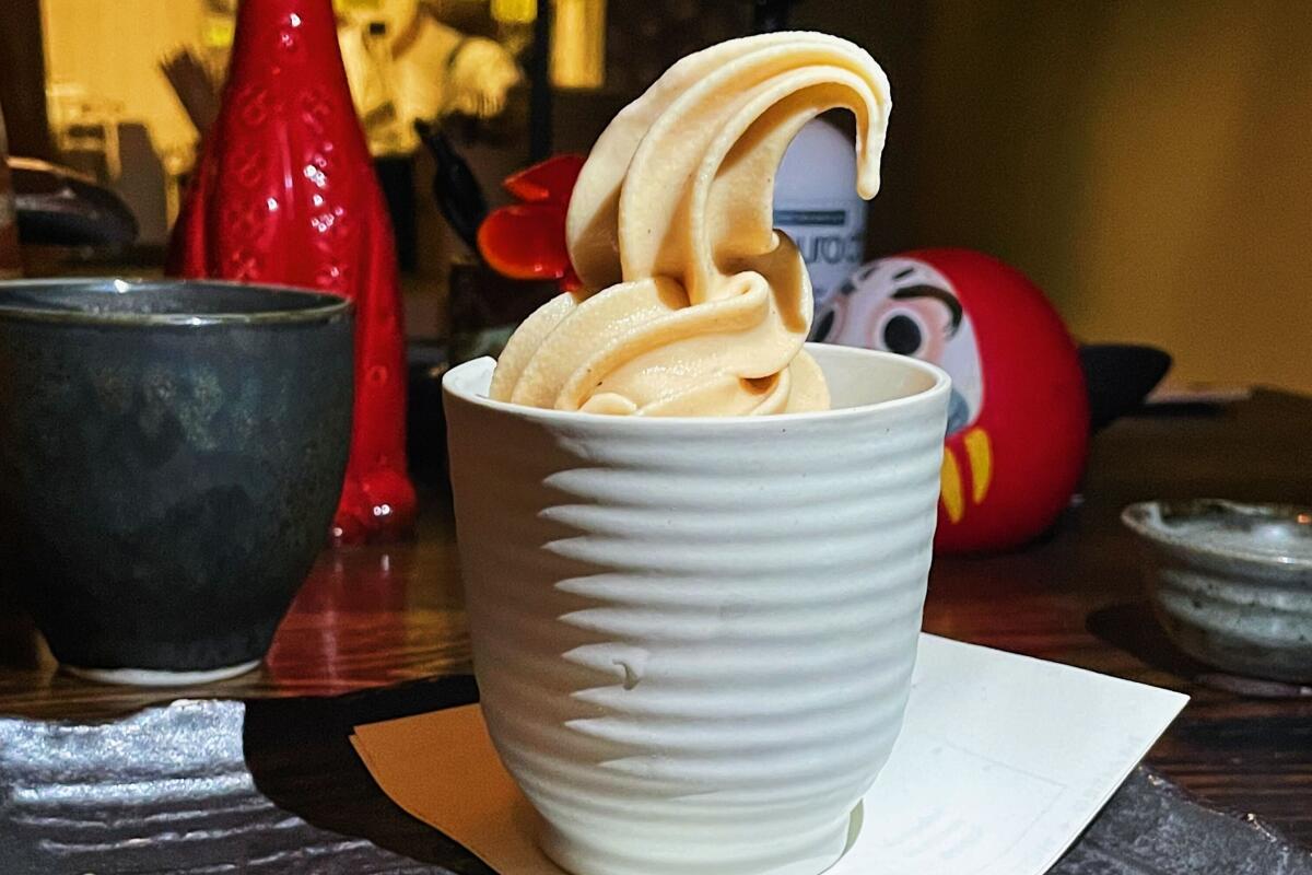 Roasted green tea-infused chocolate soft serve ice cream in a horizontally ribbed ceramic cup.
