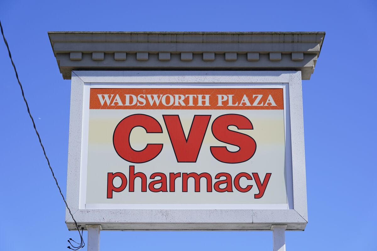 This Sept. 29, 2021 photo shows a sign for the CVS in Wadsworth Plaza in Philadelphia. COVID-19 vaccines and tests for the virus continued to boost CVS Health in the first quarter, and the health care giant finally raised its annual forecast. The drugstore chain and pharmacy benefit manager said Wednesday, May 4, 2022, that it now expects earnings of $8.20 to $8.40 per share for 2022. (AP Photo/Matt Rourke)