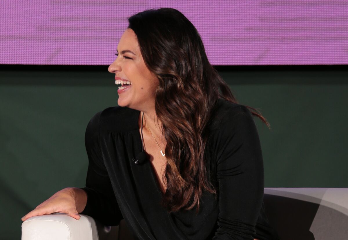 Jessica Mendoza laughs on a couch at a 2021 event.