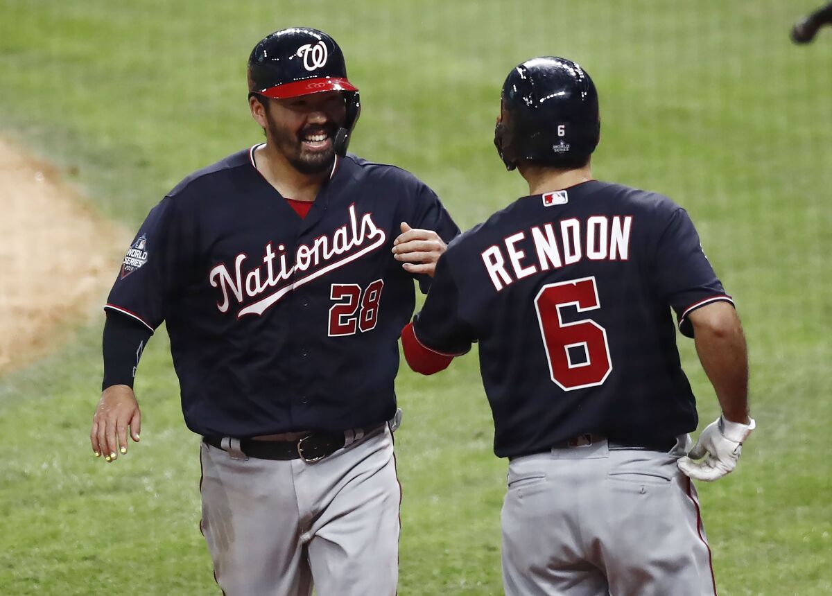  Washington Nationals' Kurt Suzuki, left, celebrates with teammate Anthony Rendon after scoring on Adam Eaton's RBI single a in the top of the fifth inning during Game 1 of the World Series on Tuesday in Houston.