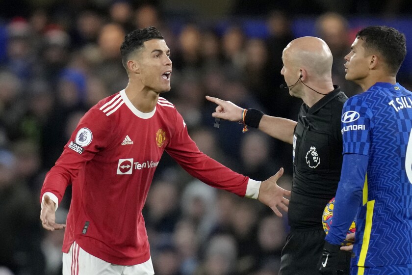 Cristiano Ronaldo del Manchester United discute con el árbitro Anthony Taylor y frente a Thiago Silve de Chelsea durante el partido de la Liga Premier, el domingo 28 de noviembre de 2021. (AP Foto/Kirsty Wigglesworth)