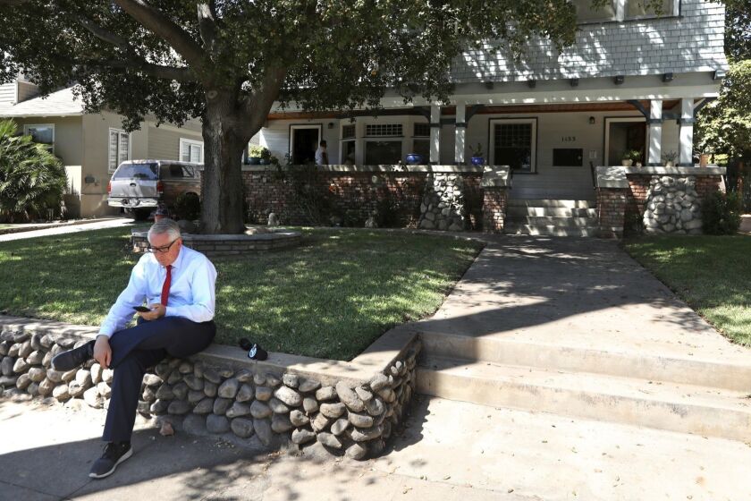 PASADENA, CA - AUGUST 31, 2018 - A reporter sits in front of the home where actress Vanessa Marquez was fatally shot by police at 1133 Fremont Avenue in Pasadena on August 31, 2018. Marquez, who appeared on the television show, "ER," in the 90s, was fatally shot by police officers after she reportedly pointed a pellet gun at them on Thursday afternoon according to officials. (Genaro Molina/Los Angeles Times)