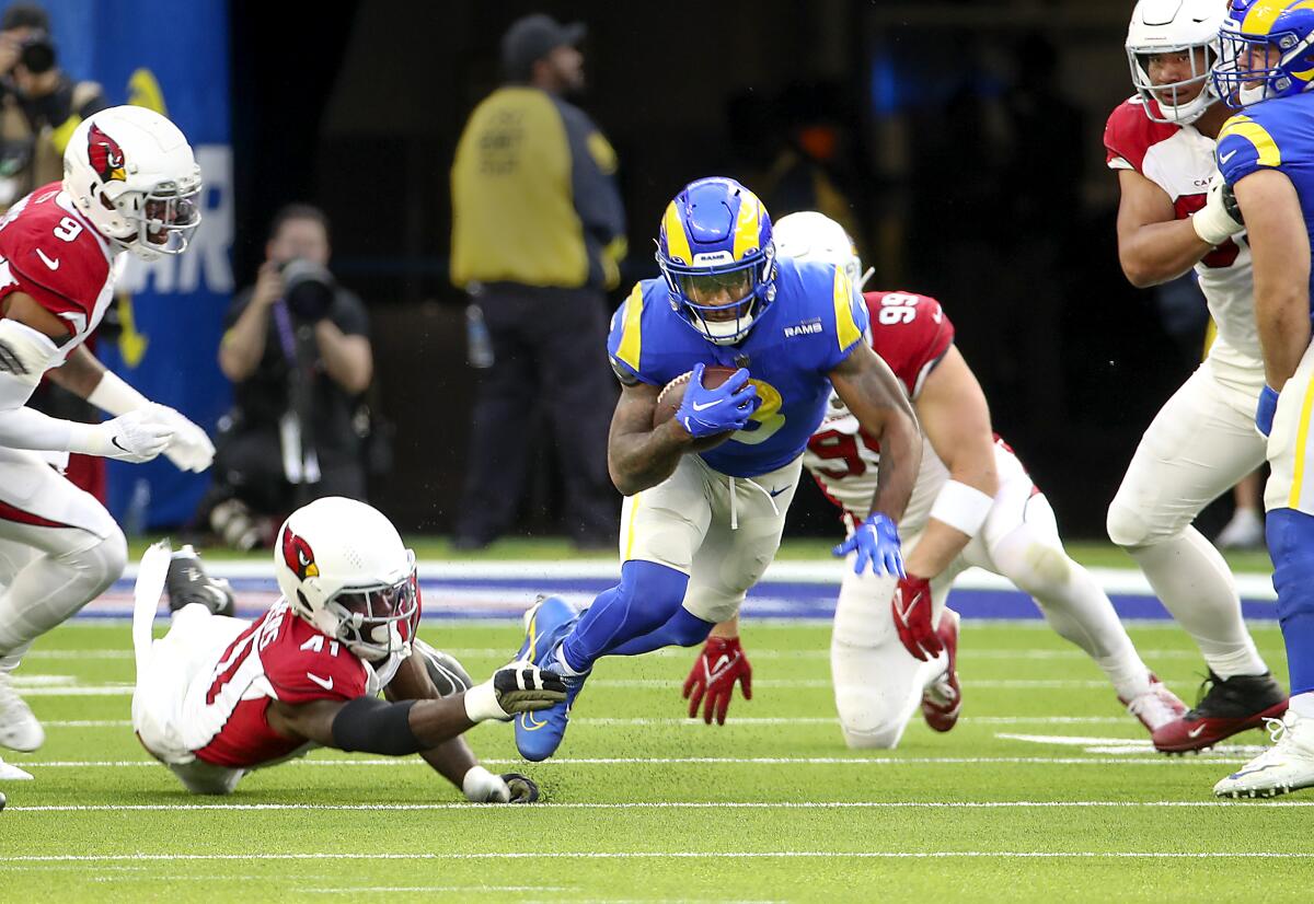 Cardinals linebacker Myjai Sanders trips Rams running back Cam Akers in the first quarter.