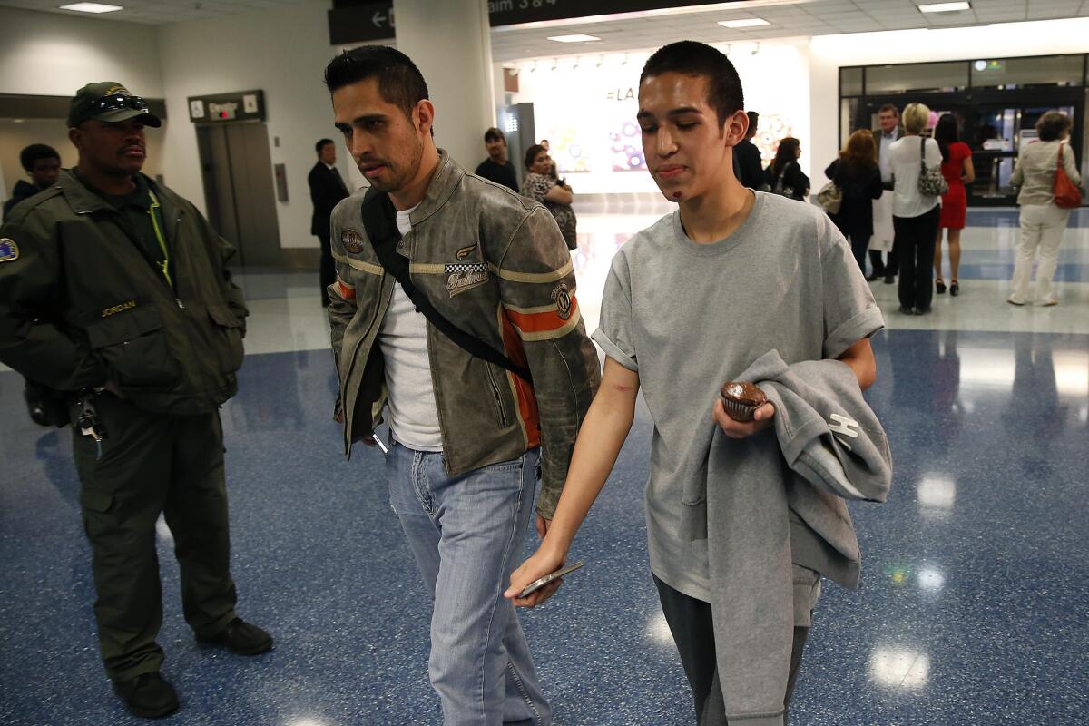 Jonathan Gutierrez and his father, Javier, arrive at LAX from Sacramento on Friday, a day after surviving a bus crash in Orland.