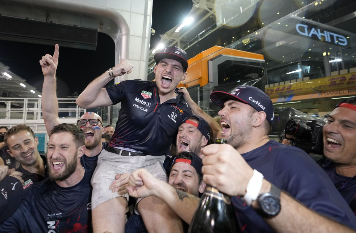 Max Verstappen of the Netherlands, center, celebrates with members of his team after winning the Formula One Abu Dhabi Grand Prix in Abu Dhabi, United Arab Emirates, Sunday, Dec. 12, 2021. Max Verstappen ripped a record eighth title away from Lewis Hamilton with a pass on the final lap of the Abu Dhabi GP to close one of the most thrilling Formula One seasons in years as the first Dutch world champion. (AP Photo/Hassan Ammar)