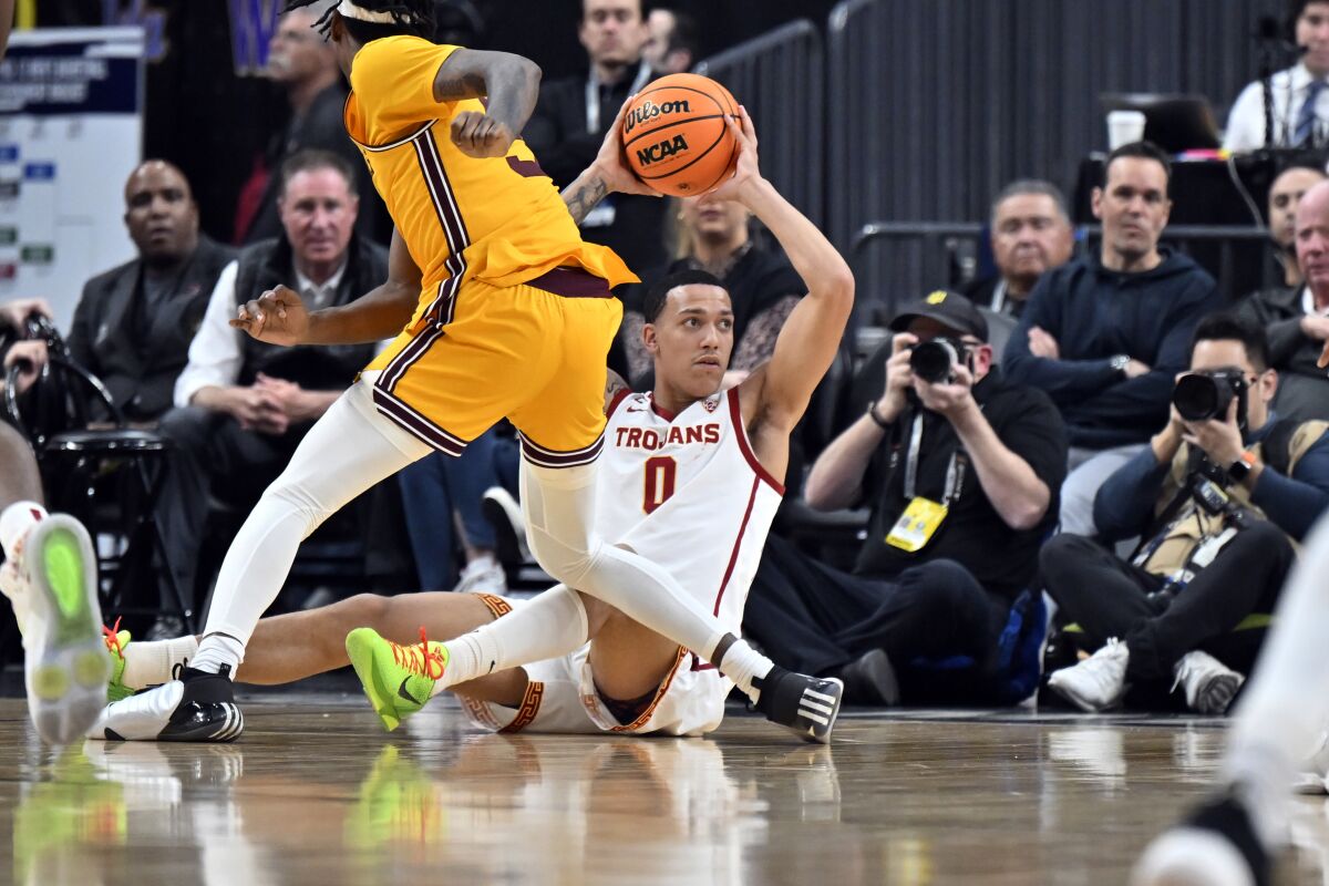 USC forward Kobe Johnson tries to pass, while Arizona State forward Jamia Neal defends.