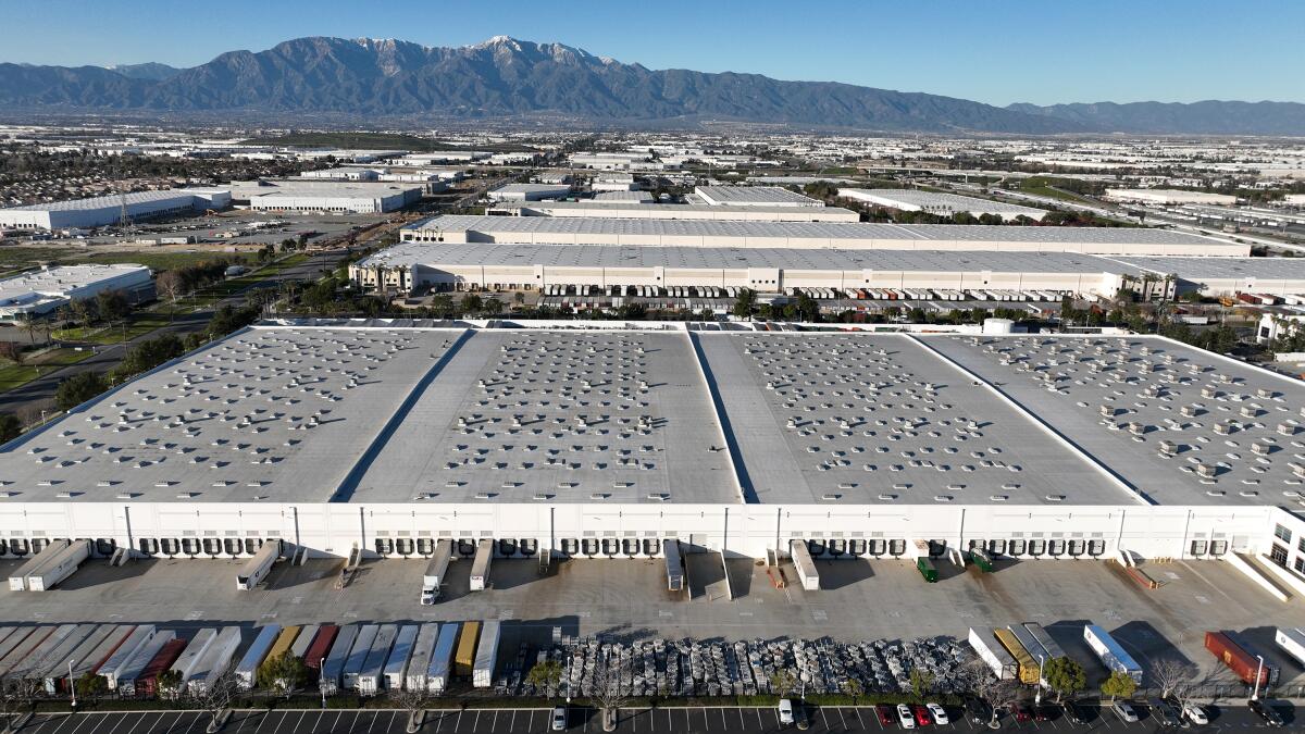 Large warehouses cover the landscape in an aerial shot.