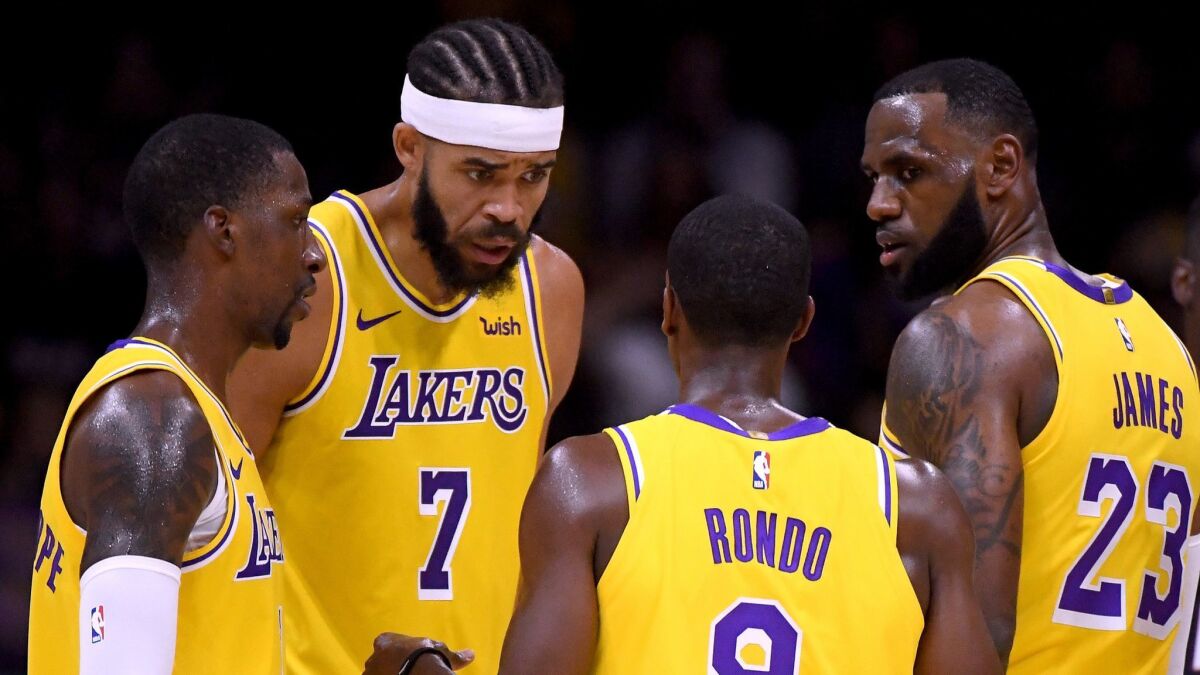 Lakers' LeBron James (23), Rajon Rondo (9), JaVale McGee (7) and Kentavious Caldwell-Pope (1) talk after a stop in play during a preseason game against the Nuggets at Valley View Casino Center on Sept. 30 in San Diego.
