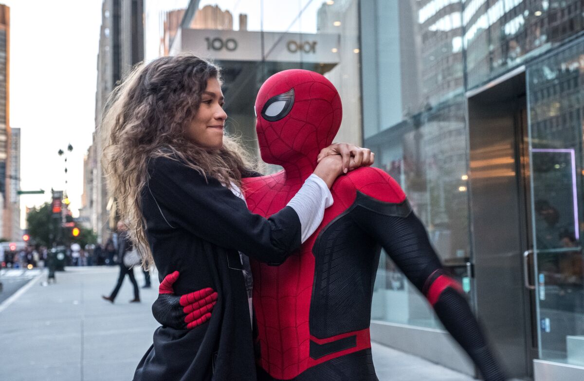 A woman with long, brown hair hugging a man in a Spider-Man suit