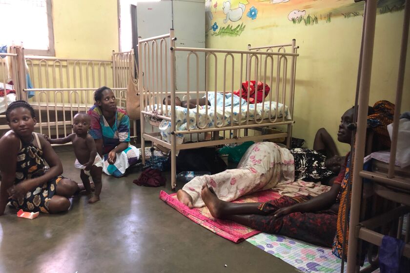 A group of mothers and children infected with measles wait in a makeshift isolation ward at Mulago Hospital in Kampala, Uganda.