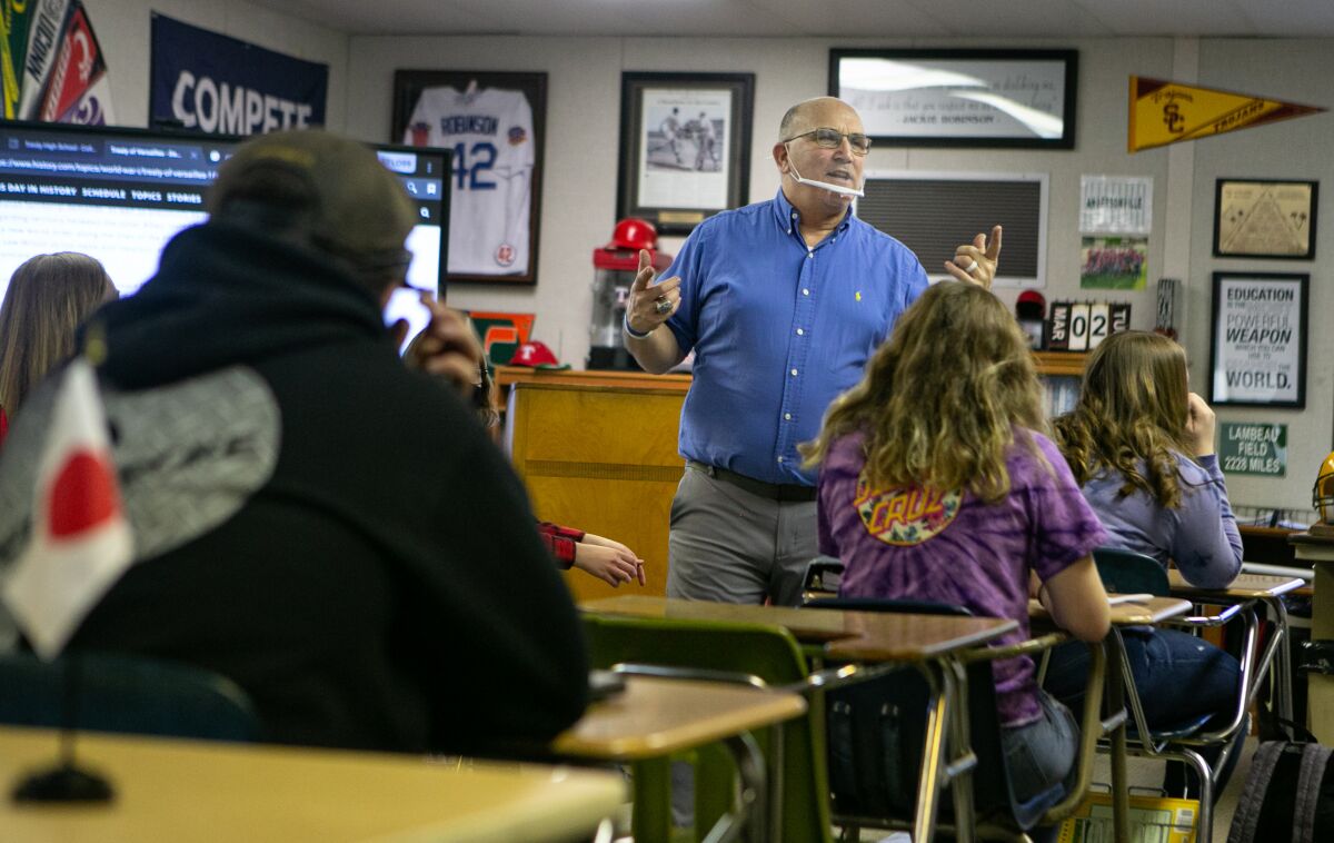 Teacher Bob Anderson speaks at the front of his classroom to students sitting at desks.