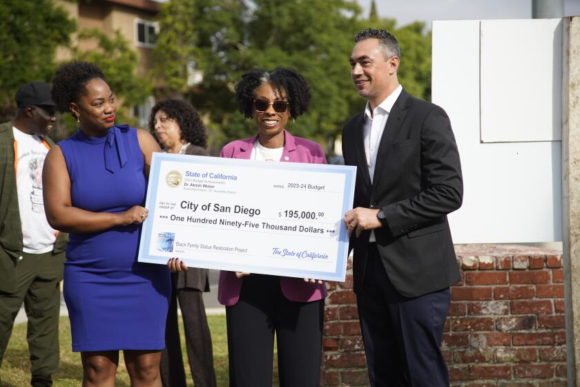 San Diego, California - October 10: Assemblymember Dr. Akilah Weber secured $195,000 for San Diego to restore and rebuild the historic "Black Family" statue near Mountain View Park. Assemblymember Akilah Weber, M.D. hands a check to Council President pro Tem Monica Montgomery Steppe and Council President Sean Elo-Rivera in Mountain View on Tuesday, Oct. 10, 2023 in San Diego, California. (Alejandro Tamayo / The San Diego Union-Tribune