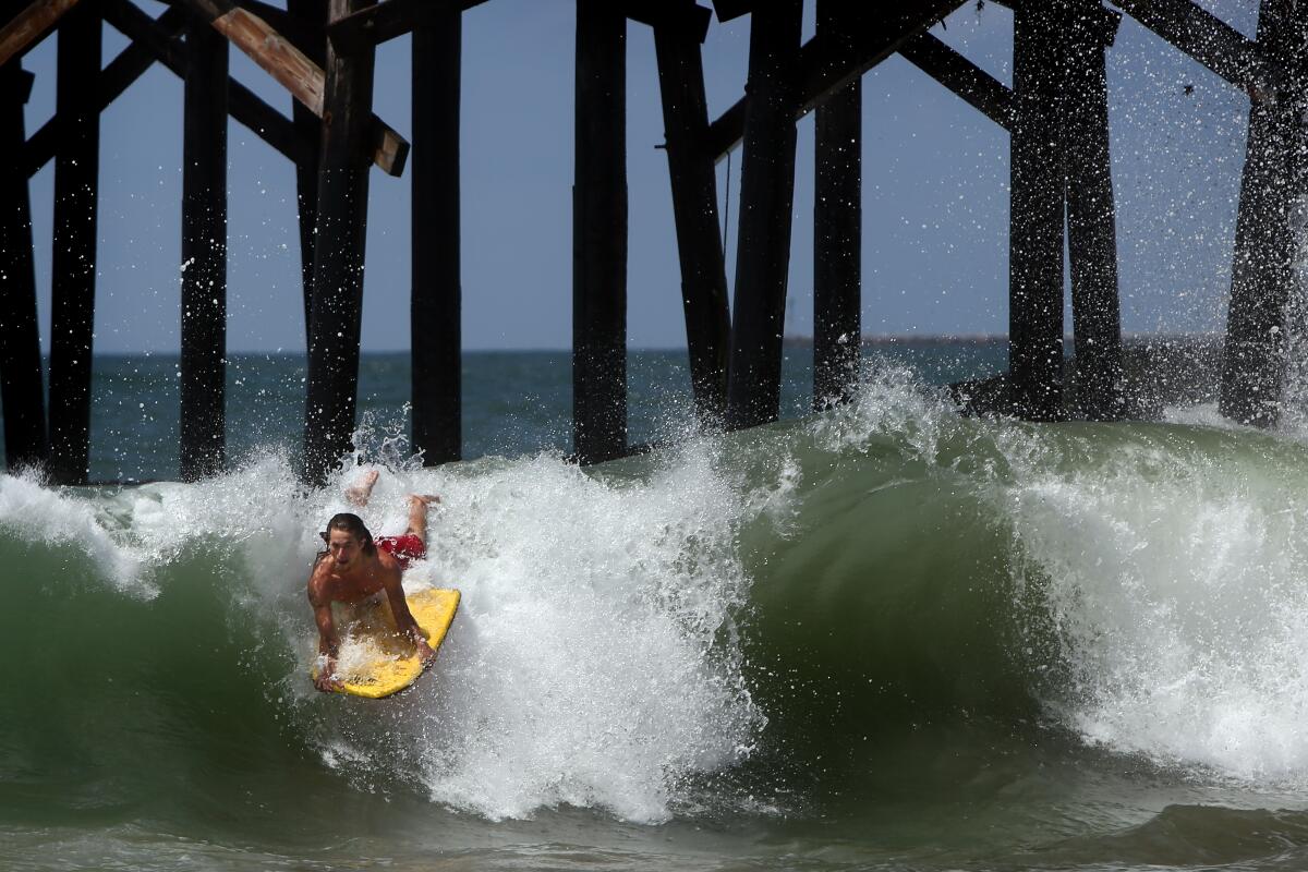 Daniel Boyd boogie boards at Seal Beach on Monday, as the city reopened the beach to active use during daylight hours Monday through Thursday