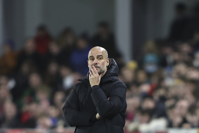 Manchester City's head coach Pep Guardiola watches during the English Premier League soccer match between Brentford and Manchester City at the Brentford Community Stadium in London, Wednesday, Dec. 29, 2021. (AP Photo/Ian Walton)