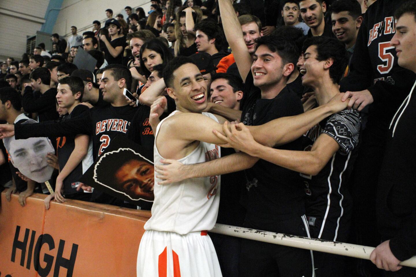Beverly Hills High center Chance Comanche celebrates a win over Santa Monica with Beverly Hills students.
