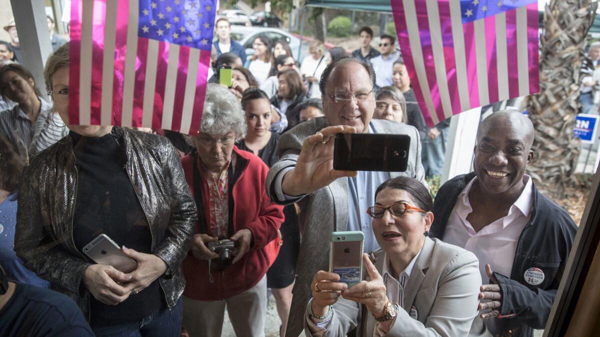 An overflow crowd watches through a window during a rally with Kamala Harris at the Democratic Party's headquarters in Santa Clarita.