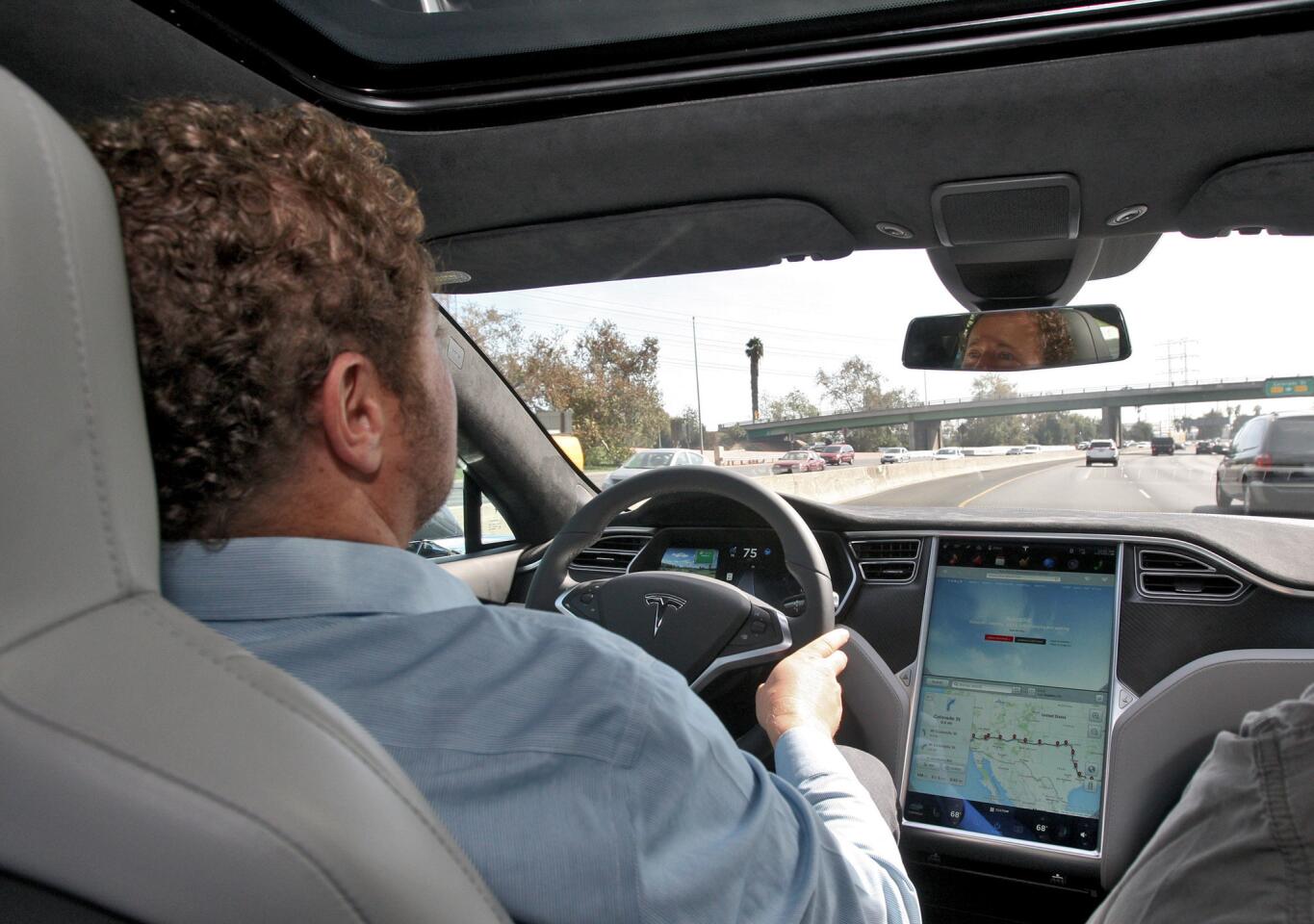 Tesla Motors S.W. Region General Manager Jeremy Snyder shows the electric car's Ludicrous speed setting, 0-60 in 2.8 seconds and the auto pilot feature, in Burbank on Friday, October 23, 2015. Ludicrous speed setting can create a force of 1 gravity on the vehicle's occupant and the auto pilot feature can apply the brakes or change lanes without the driver's help. The showroom, where a customer can order their own personalized Tesla electric vehicle, will soon have a customer lounge and charging stations.