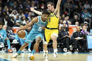 Dennis Smith Jr. (8), de los Hornets de Charlotte, intenta superar a T.J. McConnell (9), de los Pacers de Indiana, durante la primera mitad del juego de baloncesto de la NBA, el lunes 20 de marzo de 2023, en Charlotte, Carolina del Norte. (AP Foto/Matt Kelley)