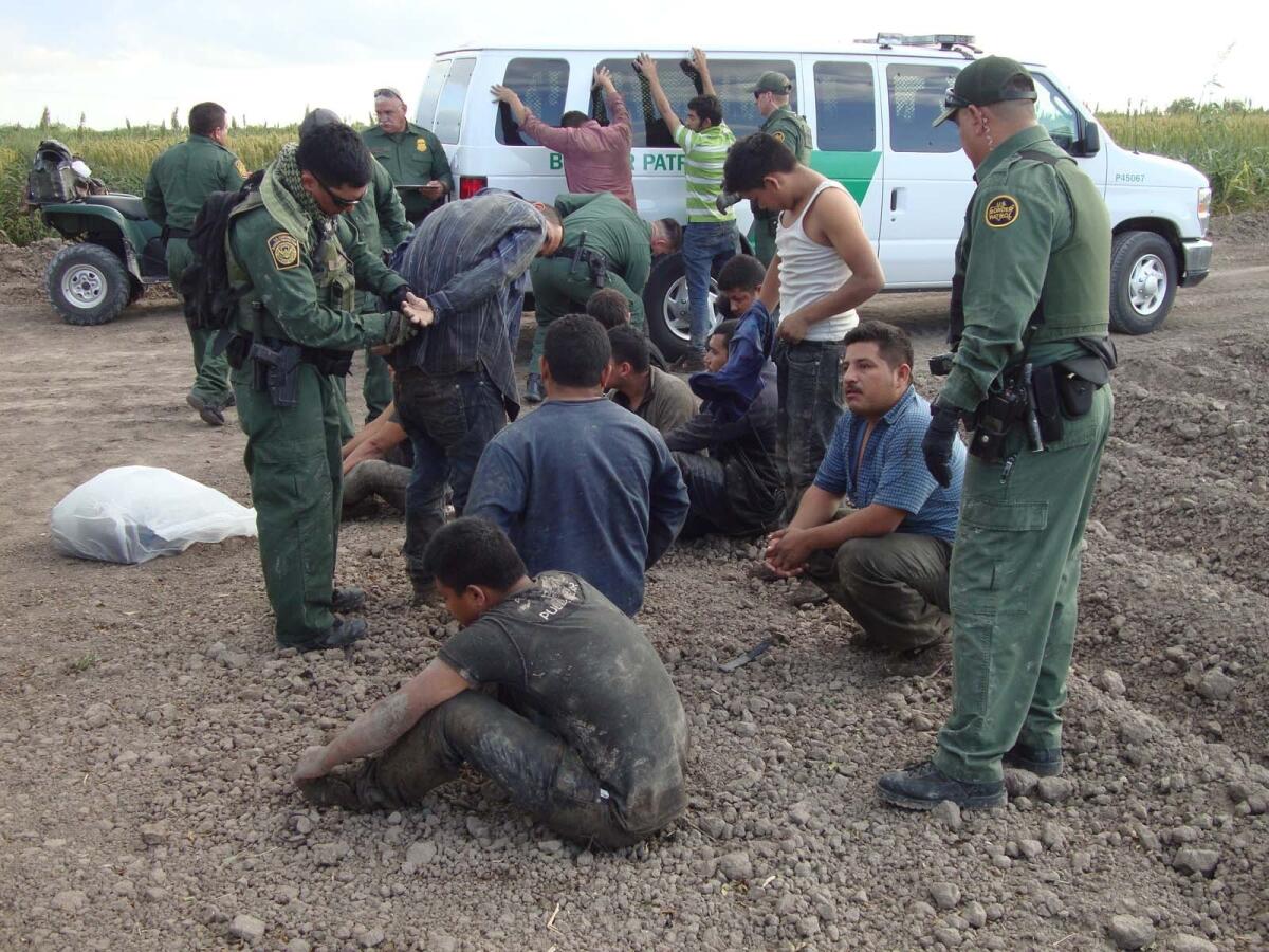 Texas Border Patrol agents detain migrants crossing into the U.S. illegally. An agent fired several shots toward an armed militia member during the course of a pursuit near the border on Friday.