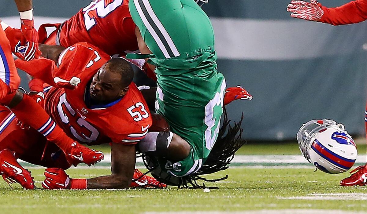 Buffalo's Nigel Bradham loses his helmet while tackling New York Jets' Chris Ivory on Thursday night.