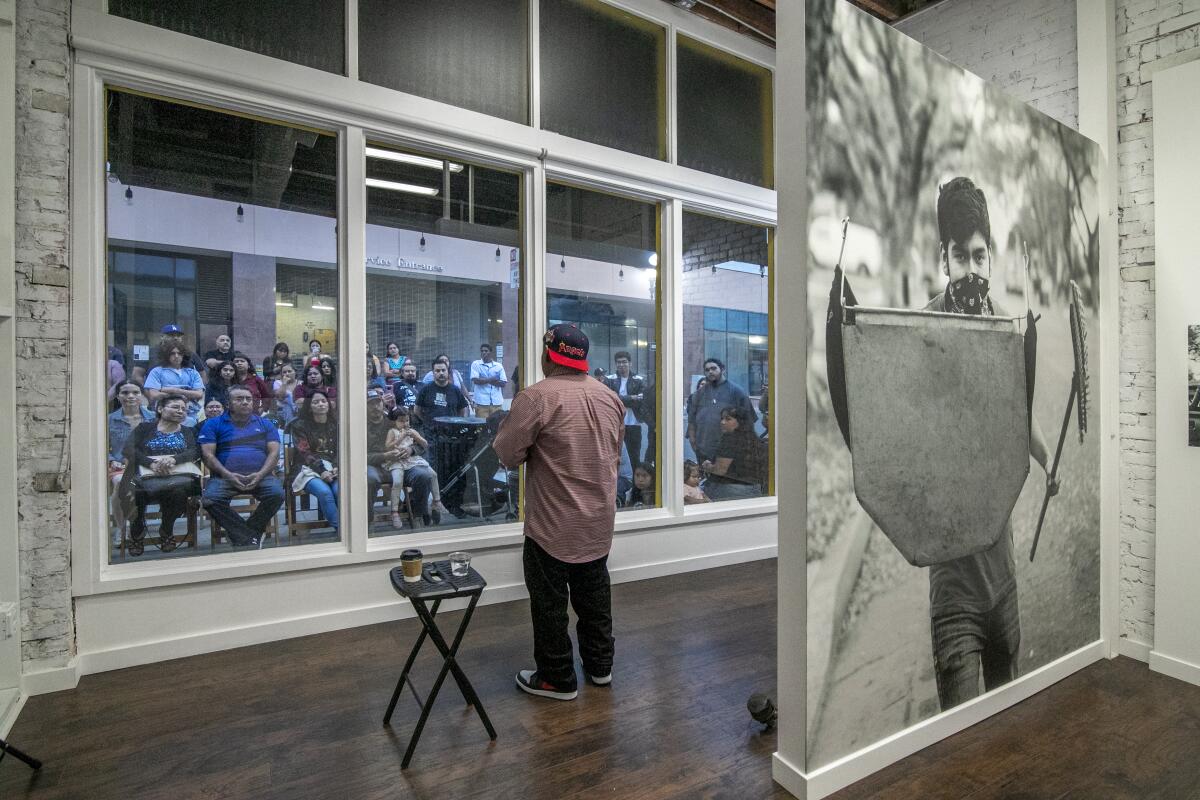 Artist Jesus Cortez speaks to his audience from the Crear Studio window on West Fifth Street in Santa Ana.