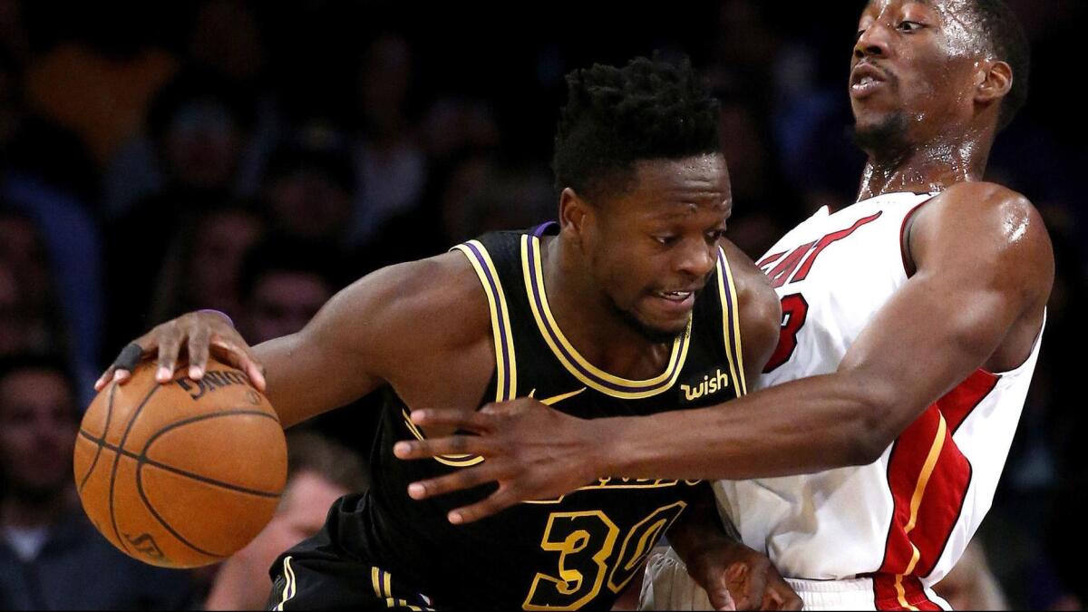Lakers forward Julius Randle powers his way to the basket against Heat center Bam Adebayo during a game March 16.