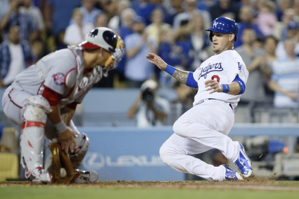 The Dodgers' Yasmani Grandal scores on a triple by teammate Yasiel Puig before Nationals catcher Wilson Ramos can apply the tag in the fifth inning Tuesday night.