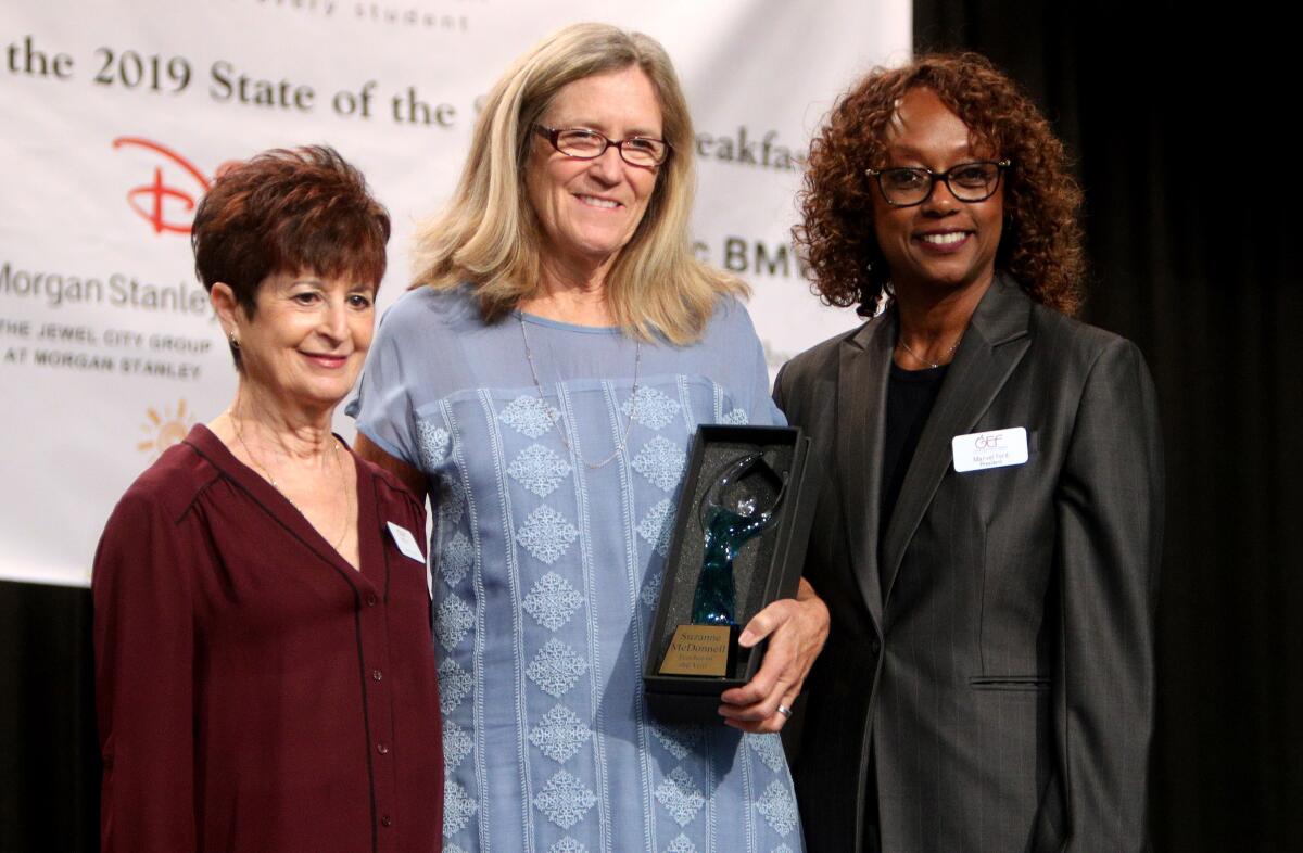 Glendale Unified Teacher of the Year Suzanne McDonnell, center, stands with Glendale Educational Foundation's Karen Swan, left, and Marvel Ford, right, at the 2019 State of the Schools Breakfast in Glendale on Thursday.