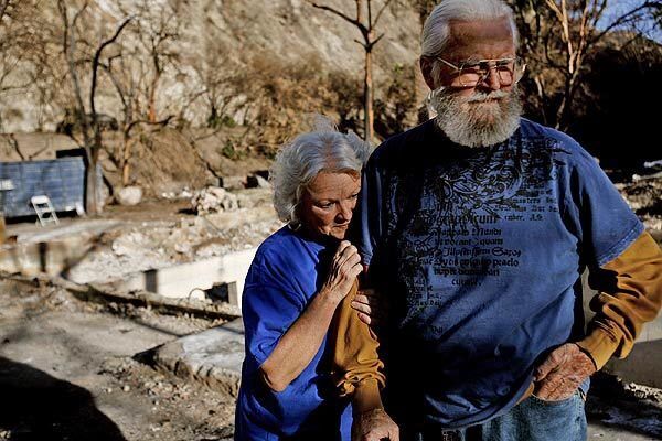 Nancy Gjerset, 61, holds on tight to her husband, Ron, in the ashes of their home in Big Tujunga Canyon. The house was among dozens of dwellings destroyed by the Station fire, which burned 250 square miles of the Angeles National Forest