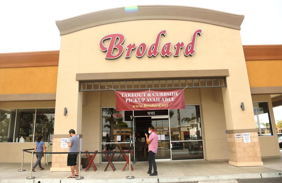 Customers keep socially distant while waiting in line while at Brodard Restaurant in Fountain Valley.