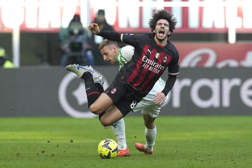 Sandro Tonali del Milan recibe una falta de Davide Frattesi de Sassuolo durante el partido de la Serie A, el domingo 29 de enero de 2023. (AP Foto/Antonio Calanni)