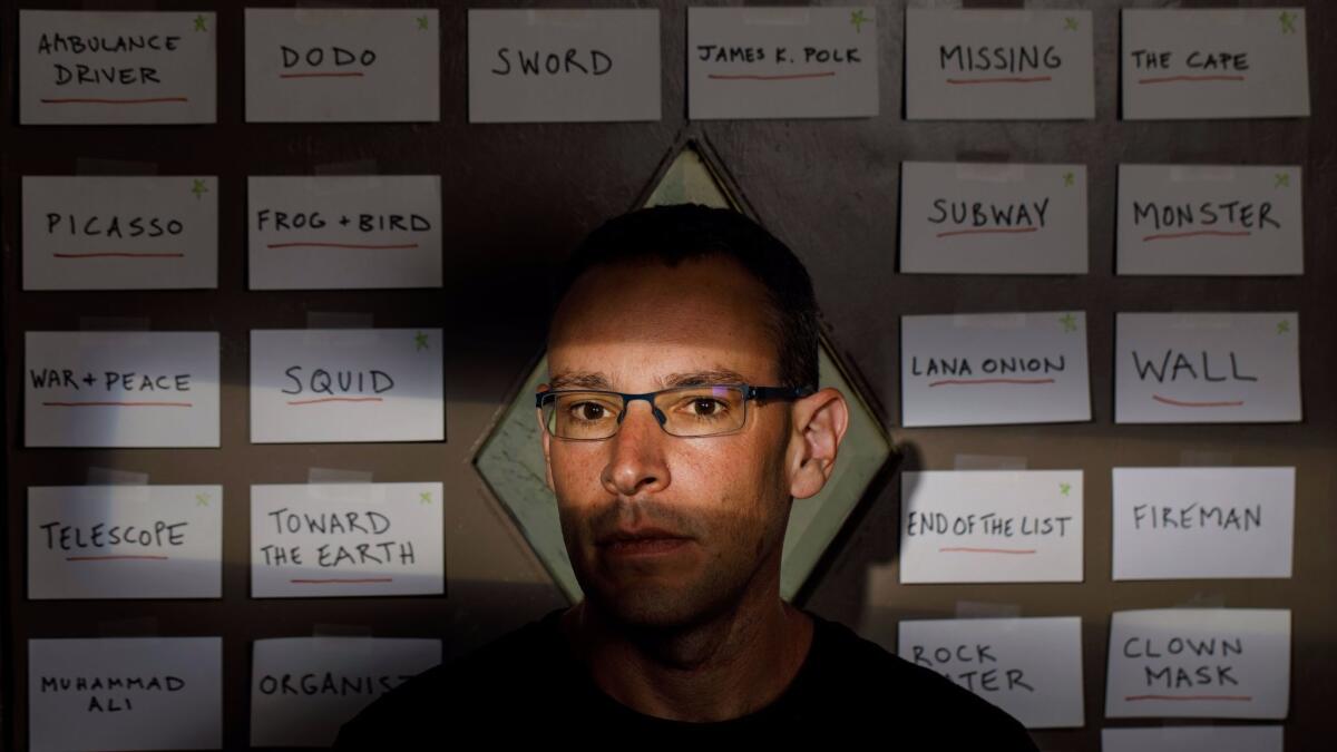 Ben Loory stands before story titles pinned to his door.