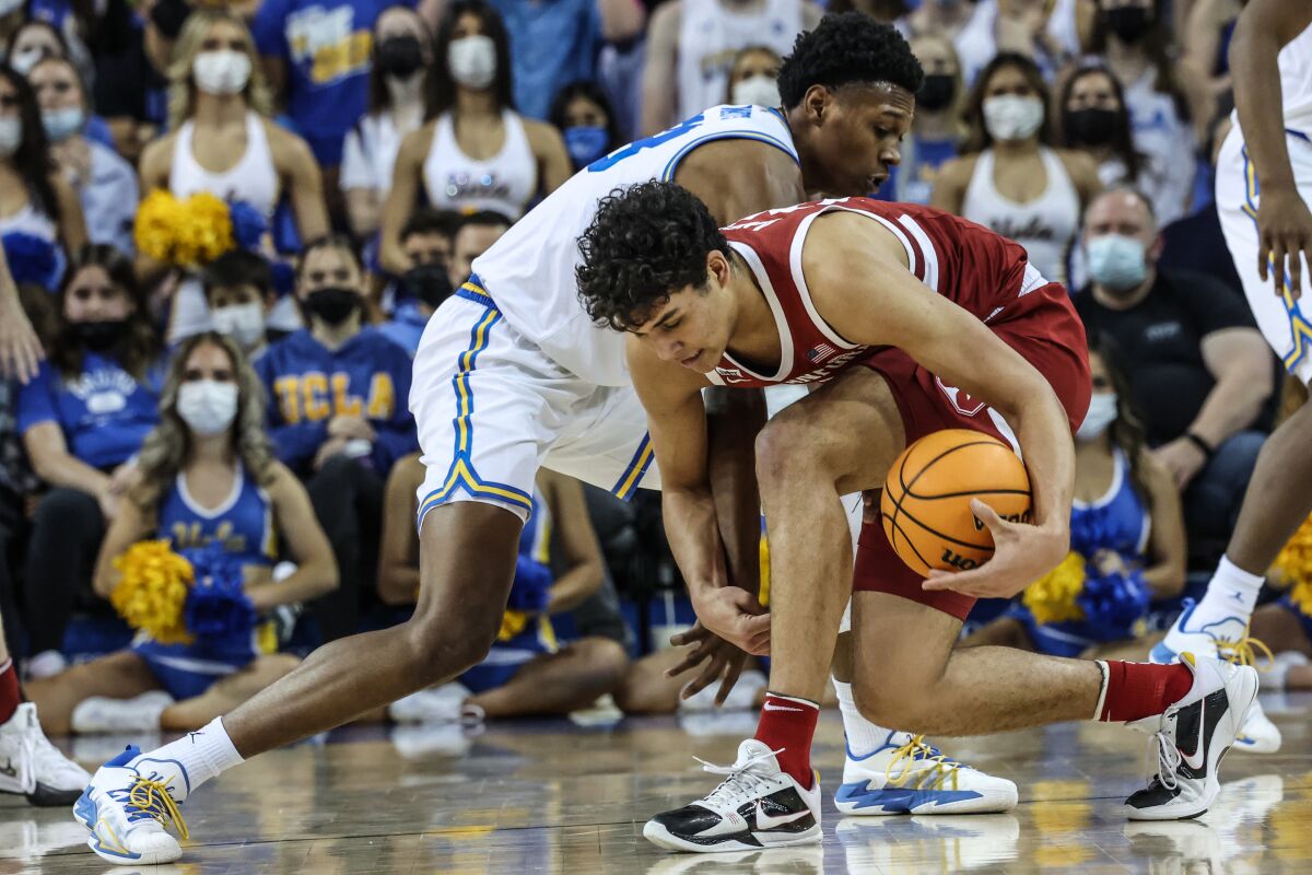 UCLA guard Peyton Watson, top, steals the ball from Stanford forward Brandon Angel during the second half.