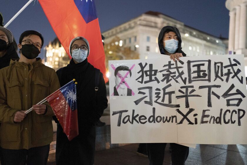 A person holds a sign as demonstrators gather at Freedom Plaza in Washington, Sunday, Dec. 4, 2022, to protest in solidarity with the ongoing protests against the Chinese government's continued zero-COVID policies. (AP Photo/Jose Luis Magana)