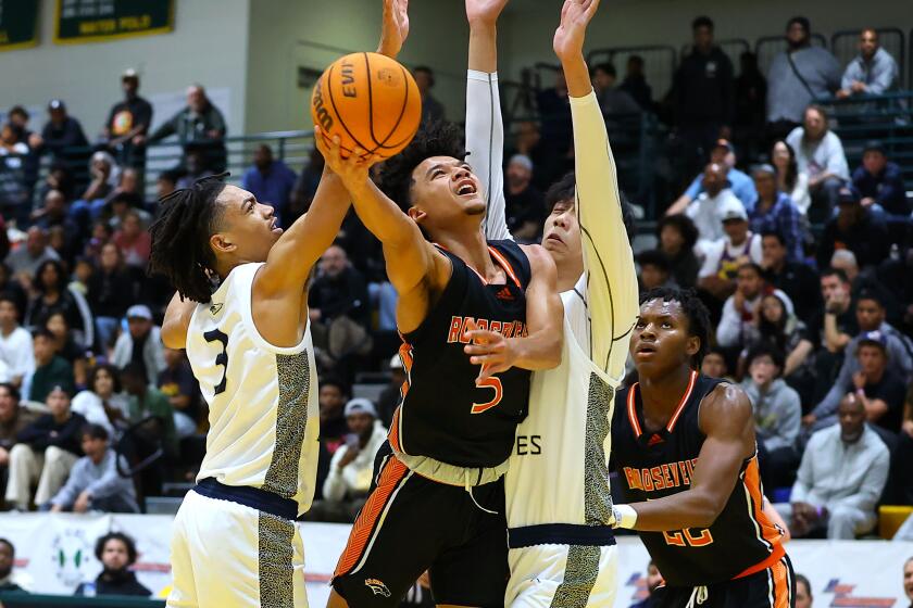 Brayden Burries of Eastvale Roosevelt goes up for shot against St. John Bosco's Elzie Harrington (3).