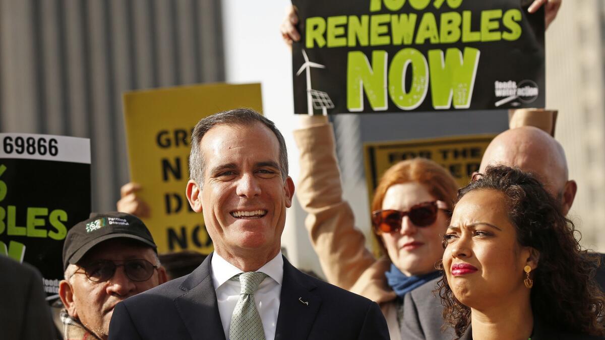 Los Angeles Mayor Eric Garcetti, left, with Aura Vasquez, right, a commissioner on the Los Angeles Board of Water and Power during a news conference outside Department of Water and Power headquarters Tuesday, Feb. 12.