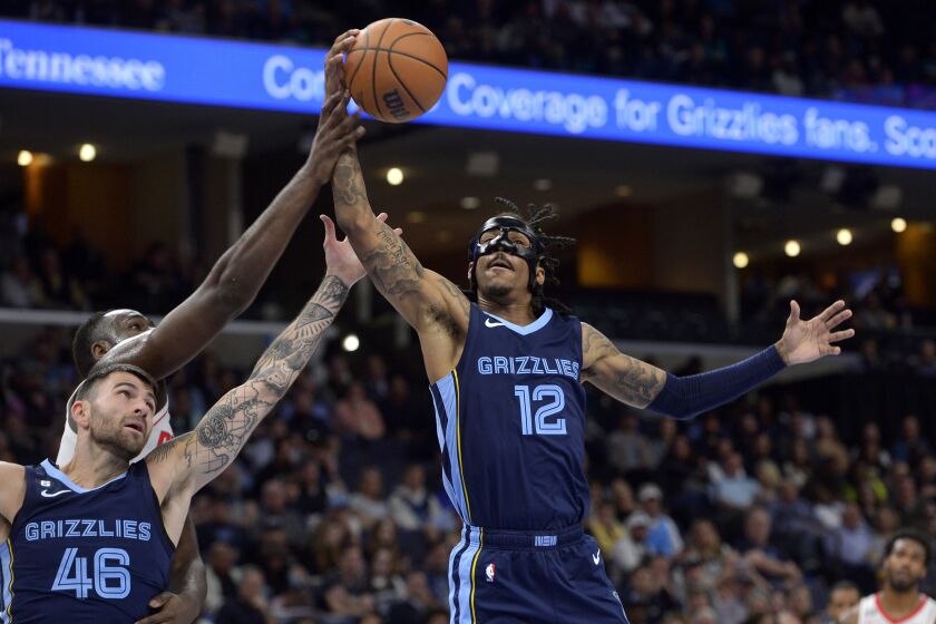 Memphis Grizzlies guards Ja Morant (12) and John Konchar (46) reach for a rebound in the first half of an NBA basketball game against the Houston Rockets Wednesday, March 22, 2023, in Memphis, Tenn. (AP Photo/Brandon Dill)