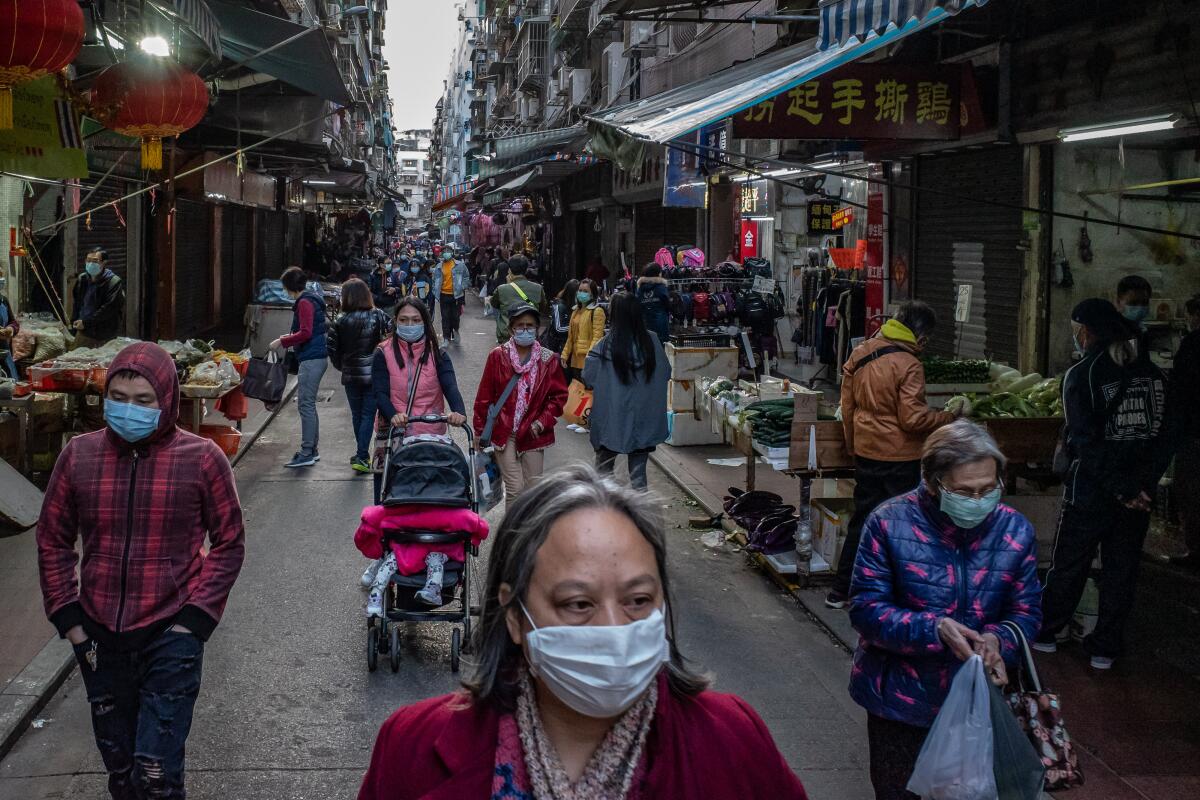 Shoppers wear face masks to guard against spreading the coronavirus at a market this week in Macau, China.