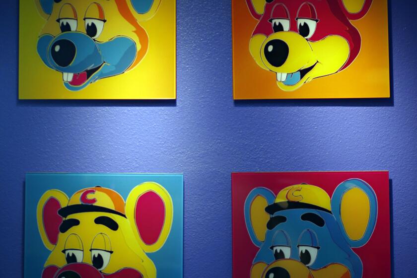 FILE - This Jan. 16, 2014 file photo shows paintings hanging on a wall at Chuck E. Cheese's in Dallas. Chuck E. Cheese pizzeria, that Mecca of fun for children but the bane of many parents, is filing for bankruptcy protection. CEC Entertainment Inc. said Thursday, Jan. 25, 2020, it was filing for voluntary protection under Chapter 11 “in order to overcome the financial strain resulting from prolonged, COVID-19 related venue closures.” (G.J. McCarthy/The Dallas Morning News via AP)