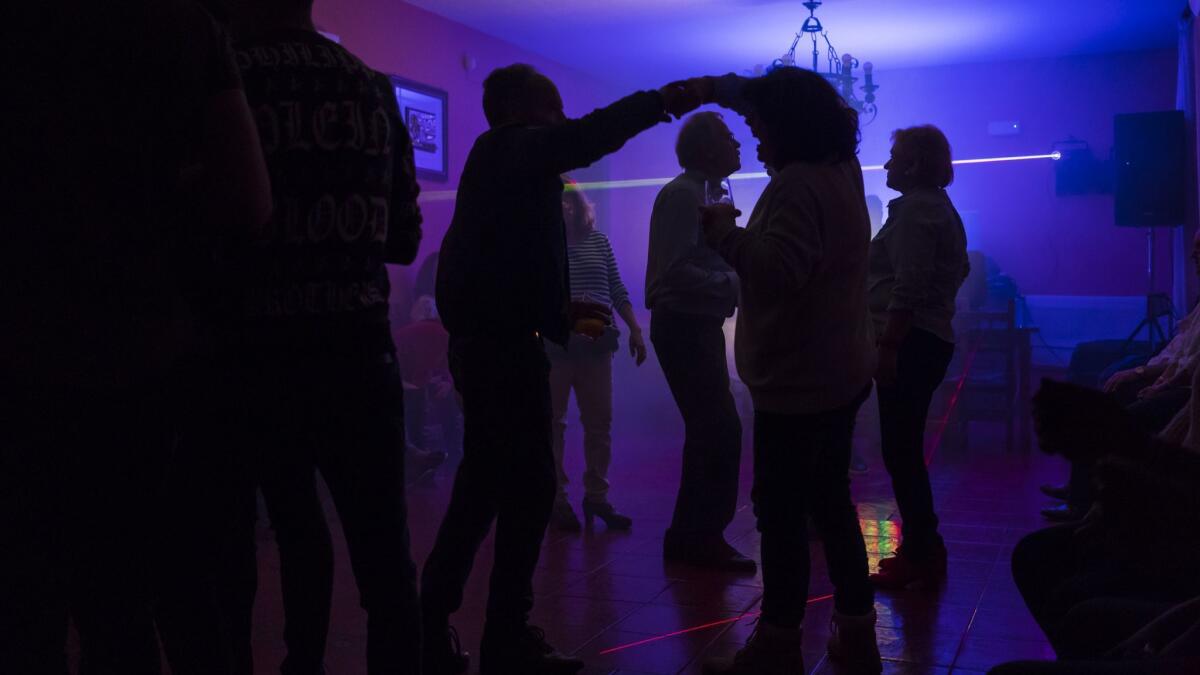 Participants of the caravan dance with men in Calzadilla de la Cueza, Spain.