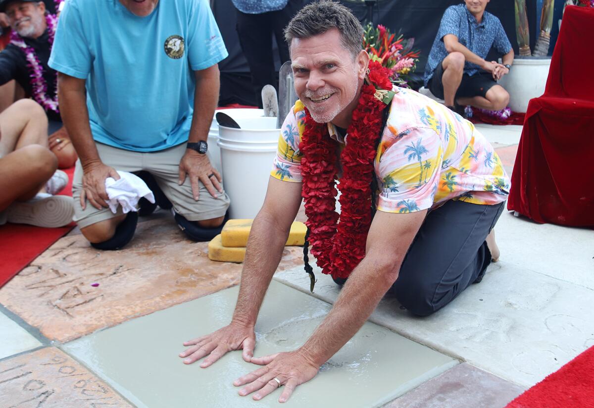 Surfers' Hall of Fame inductee Jeff Deffenbaugh smiles as he places his hands in cement for Friday's ceremony.