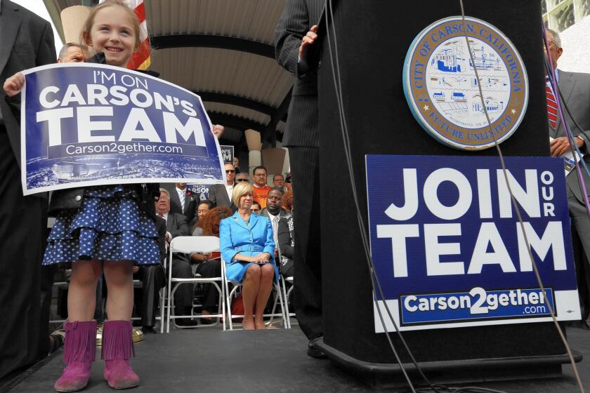 Rose Lehane, 6, and others wait for Rep. Janice Hahn (D-Los Angeles) to speak at a news conference at the proposed stadium site in Carson.